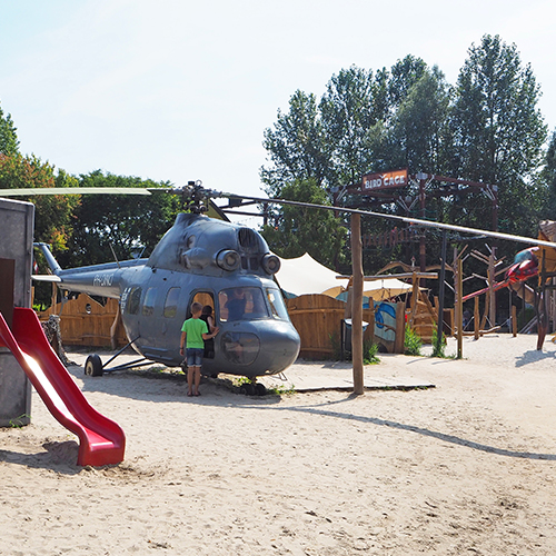 Buitenspeeltuin met speelberg, vliegtuig, helikopter en jeep
