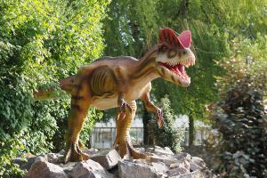 Dilophosaurus van Dinoland schreeuwt over het park met de bek wagenwijd open.